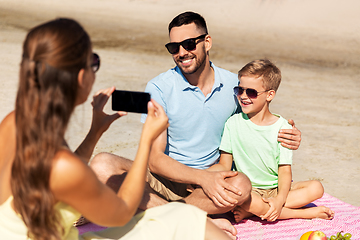 Image showing family with smartphone photographing on beach