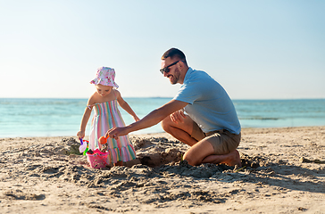 Image showing father and daughter playing with toys on beach