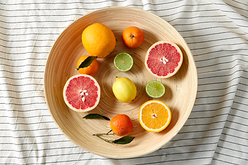 Image showing close up of citrus fruits on wooden plate