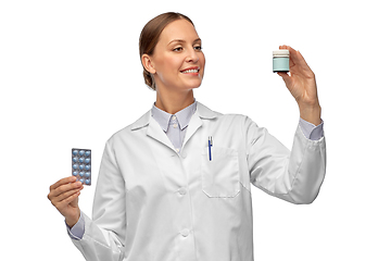 Image showing smiling female doctor holding medicine pills