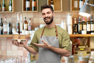 Image showing happy smiling barman in apron with takeaway coffee