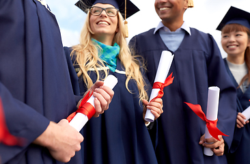 Image showing graduate students in mortar boards with diplomas