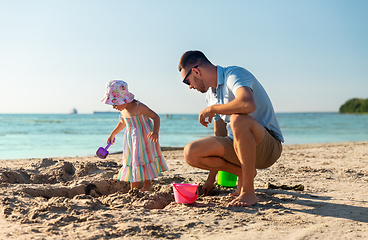 Image showing father and daughter playing with toys on beach