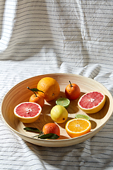 Image showing close up of citrus fruits on wooden plate