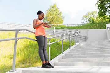 Image showing happy african woman with fitness tracker outdoors