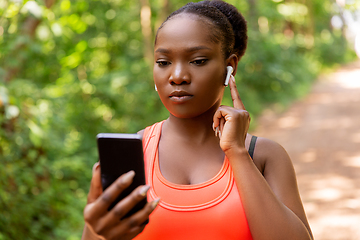 Image showing african american woman with earphones and phone