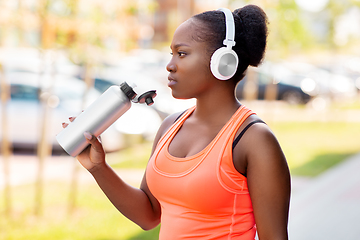 Image showing african american woman drinking water after sports