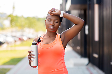 Image showing tired african american woman with bottle of water