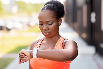 Image showing african woman with smart watch doing sports