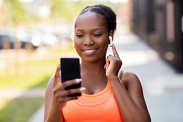 Image showing african american woman with earphones and phone