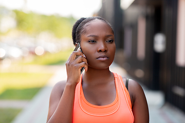 Image showing sporty african woman calling on smartphone in city