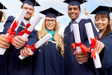 Image showing graduate students in mortar boards with diplomas