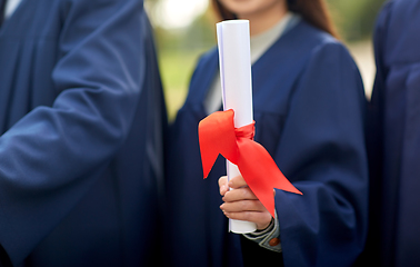 Image showing graduate students in mortar boards with diplomas