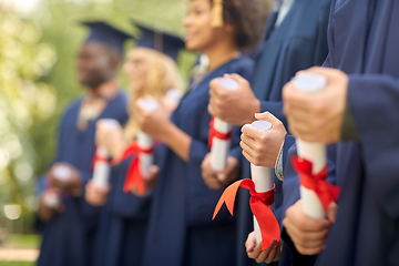 Image showing graduate students in mortar boards with diplomas