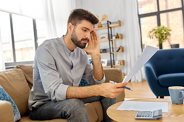 Image showing stressed man with bills at home