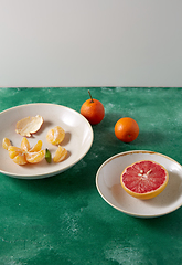 Image showing peeled mandarins and grapefruit on plates