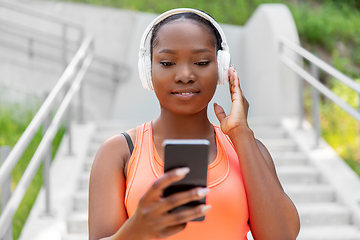 Image showing african american woman with headphones and phone