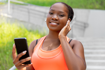 Image showing african american woman with earphones and phone