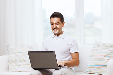 Image showing happy man with vitiligo and laptop at home