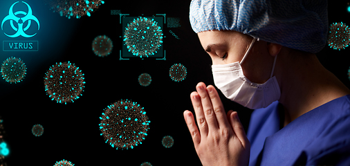 Image showing female doctor or nurse in face mask praying