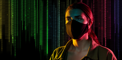 Image showing female hacker in black mask over binary code