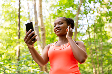 Image showing african american woman with earphones and phone