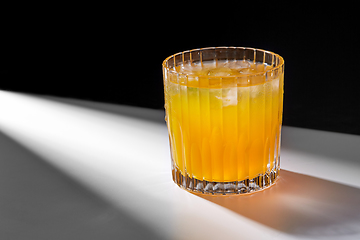 Image showing glass of orange juice with ice on table