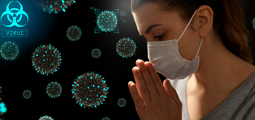 Image showing sick young woman in protective face mask praying