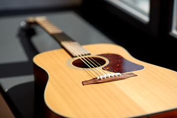 Image showing close up of acoustic guitar on window sill