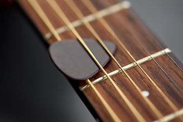 Image showing close up of guitar neck with pick between strings