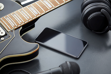 Image showing close up of bass guitar and smartphone