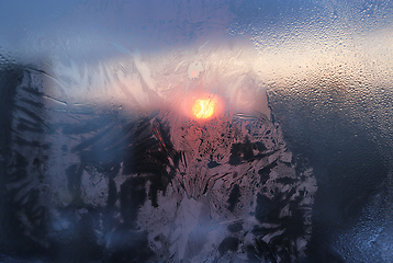 Image showing Ice pattern and water drops on glass on a sunny winter morning