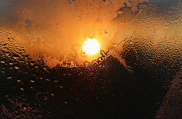 Image showing Ice patterns, water drops and sunlight on a winter window glasss