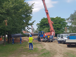 Image showing Laying heating pipes in a trench at construction site. Reconstru