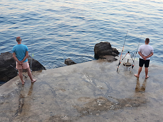 Image showing Two fishermen are waiting for the fish to bite