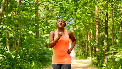 Image showing young african american woman running in forest