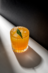 Image showing glass of orange juice with ice on table