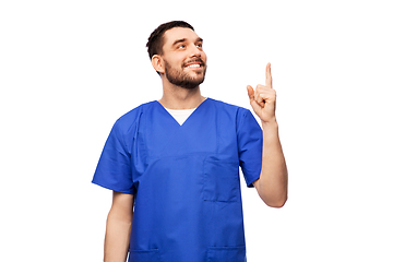 Image showing smiling doctor or male nurse pointing finger up