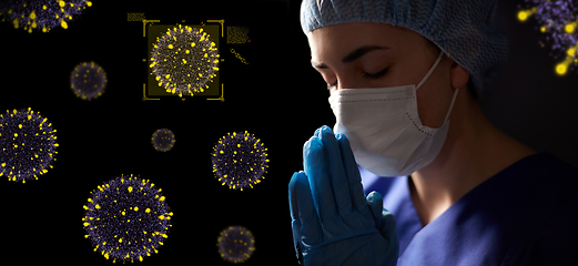 Image showing female doctor or nurse in face mask praying