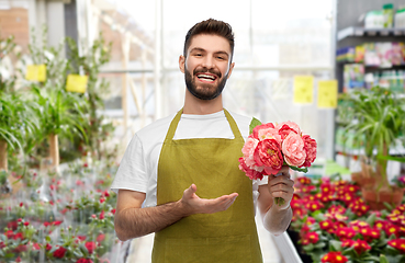 Image showing smiling male gardener with peonies at flower shop