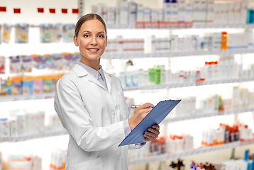 Image showing smiling female doctor with clipboard at pharmacy