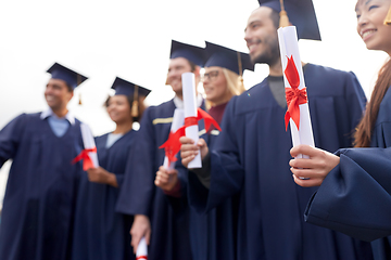 Image showing graduate students in mortar boards with diplomas