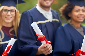 Image showing graduate students in mortar boards with diplomas