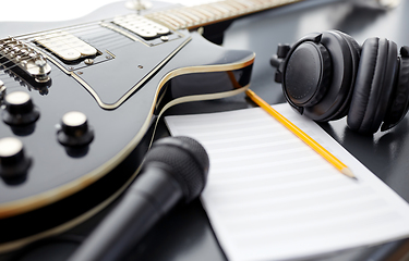 Image showing close up of guitar, music book and headphones