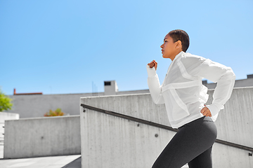 Image showing african american woman running upstairs outdoors