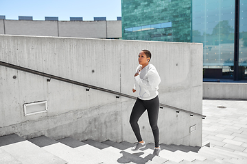 Image showing african american woman running upstairs outdoors