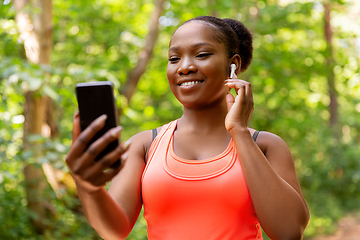 Image showing african american woman with earphones and phone