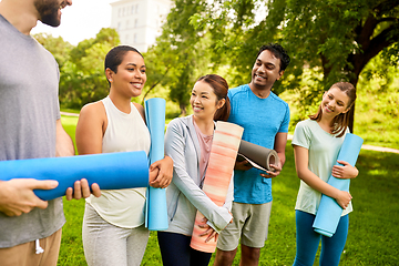 Image showing group of happy people with yoga mats at park