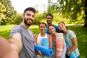 Image showing people with yoga mats taking selfie at park