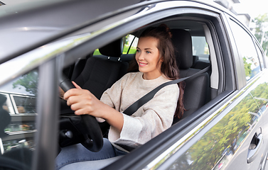 Image showing smiling woman or female driver driving car in city